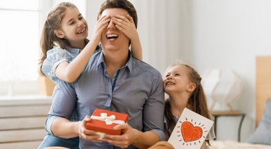 Dad getting a gift from his daughters